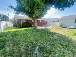 View of fully fenced back yard featuring a patio area