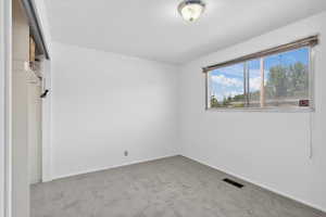 Carpeted spare room with baseboards