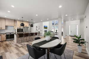 Dining space featuring recessed lighting, light wood-type flooring, and a fireplace