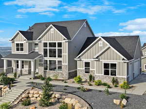 Back of house featuring board and batten siding, roof with shingles, a porch, and stone siding