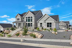 Craftsman-style house featuring board and batten siding, stone siding, roof with shingles, a garage, and a residential view