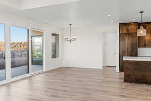 Unfurnished dining area with light wood-style flooring, a chandelier, recessed lighting, and baseboards