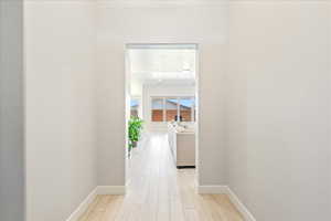 Corridor featuring baseboards and light wood-style floors