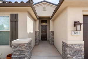 View of exterior entry with stucco siding and stone siding