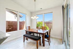 Dining space featuring a chandelier, light wood-type flooring, and baseboards