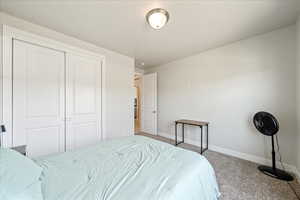Carpeted bedroom featuring baseboards and a closet