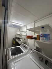Laundry room featuring washer and dryer and electric water heater