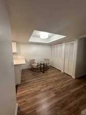 Dining space featuring dark wood-style floors, a tray ceiling, and baseboards