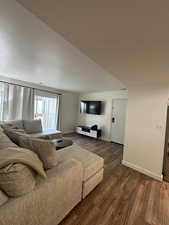 Living area with baseboards and dark wood-style flooring