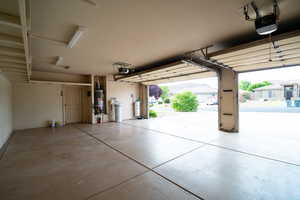 Garage with gas water heater and a garage door opener