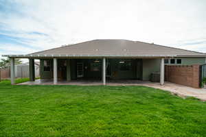 Back of property with a patio area, central air condition unit, and stucco siding