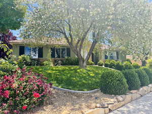 View of front of property with a front yard and stucco siding