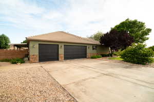 View of front of home featuring stone siding, a garage, driveway, a tile roof, and stucco siding