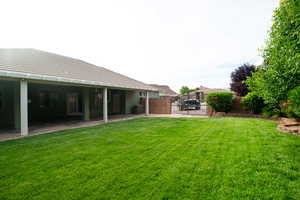 View of yard with central air condition unit, a gate, and a patio area