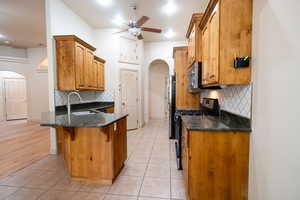 Kitchen with stainless steel appliances, arched walkways, a sink, a kitchen breakfast bar, and a peninsula