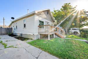 View of side of home featuring stairs and a deck