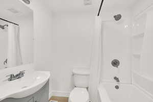 Bathroom featuring vanity, shower / bath combo with shower curtain, and wood finished floors