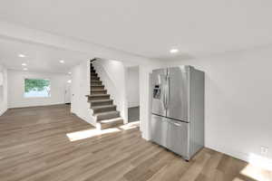Kitchen with stainless steel fridge, light wood-style flooring, recessed lighting, and open floor plan