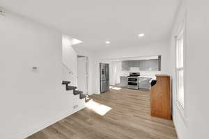 Kitchen with stainless steel appliances, gray cabinets, recessed lighting, light wood-style floors, and light countertops