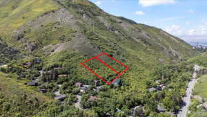 Aerial view of property and surrounding area featuring property boundaries highlighted and a mountain backdrop