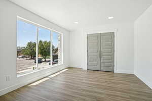 Unfurnished room featuring wood finished floors, baseboards, and recessed lighting