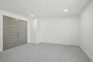 Unfurnished bedroom with carpet flooring, baseboards, recessed lighting, and a closet