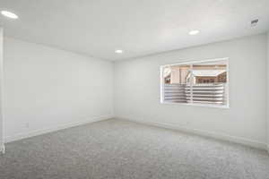 Unfurnished room featuring carpet floors, baseboards, recessed lighting, and a textured ceiling