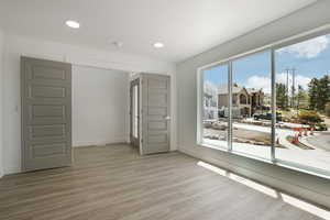 Unfurnished room with light wood-style floors, baseboards, recessed lighting, and a smoke detector