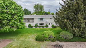 View of front of house featuring a chimney and a front yard