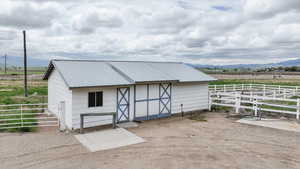 View of outbuilding featuring an exterior structure, a mountain view, and a view of rural / pastoral area