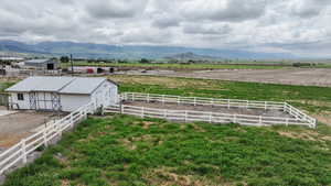 View of yard featuring an outbuilding, a view of rural / pastoral area, an exterior structure, and a mountain view