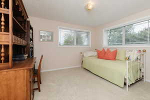 Bedroom with carpet, baseboards, and a textured ceiling