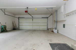 Garage featuring a garage door opener and electric panel