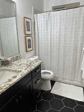 Full bath featuring vanity, toilet, and tile patterned floors