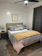 Carpeted bedroom with a ceiling fan