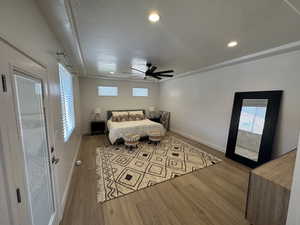 Bedroom featuring wood finished floors, baseboards, multiple windows, and recessed lighting