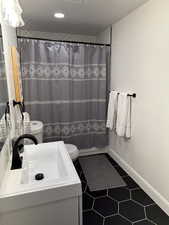 Full bathroom featuring toilet, vanity, tile patterned floors, recessed lighting, and a shower with curtain