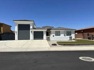 Prairie-style home with stucco siding, concrete driveway, a gate, an attached garage, and a tile roof