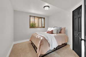Carpeted bedroom featuring baseboards