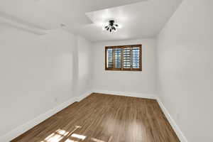Unfurnished room with wood finished floors and baseboards