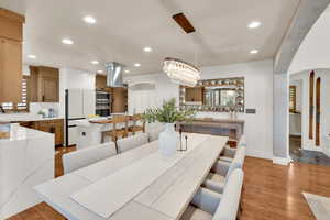 Dining room featuring recessed lighting, arched walkways, light wood-style flooring, baseboards, and a chandelier