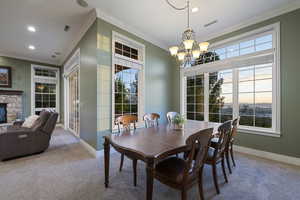 Dining room with carpet floors, ornamental molding, a chandelier, baseboards, and recessed lighting