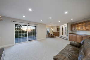 Living room featuring baseboards, recessed lighting, and light colored carpet