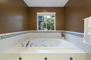 Primary full bath with a tub with jets