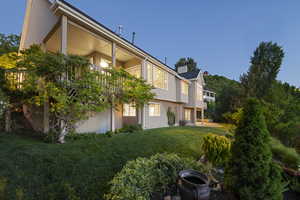 View of grassy yard featuring a balcony