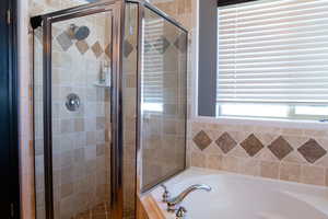 Primary Bathroom featuring a bath and a shower stall