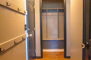 Entry from garage with closet/mud room area, with wood finished floors