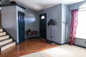 Entrance foyer with stairway, wood finished floors, baseboards