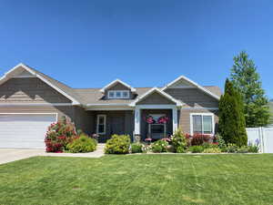 Craftsman-style home featuring a garage, covered porch, driveway, and a shingled roof