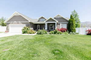Craftsman-style house with an attached garage, driveway, and stone siding
